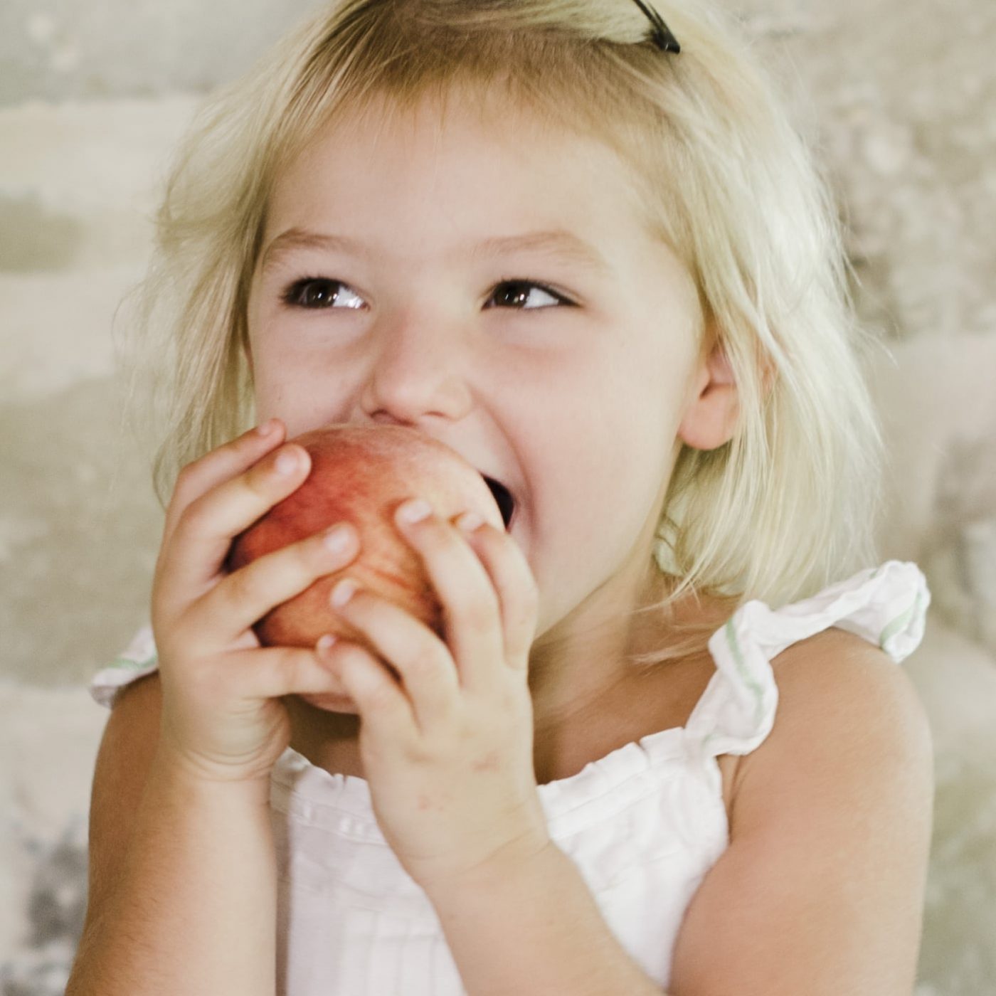 Image of child eating a peach